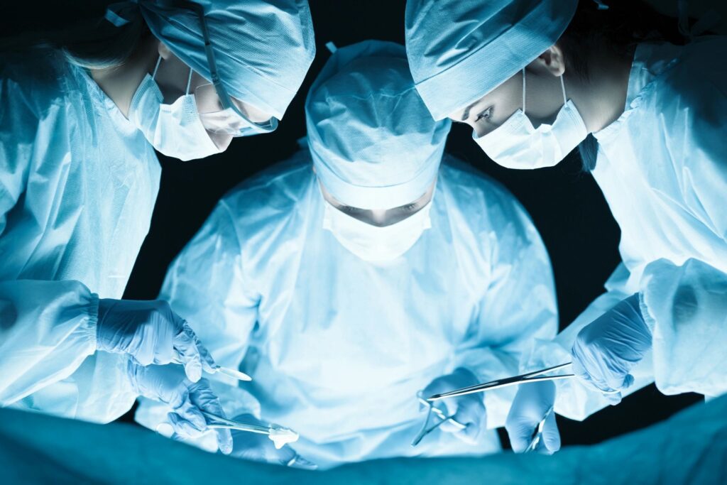 Closeup picture of three surgeons performing surgery