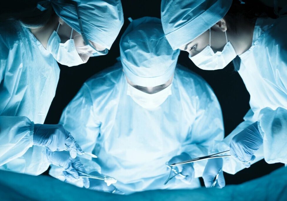 Closeup picture of three surgeons performing surgery